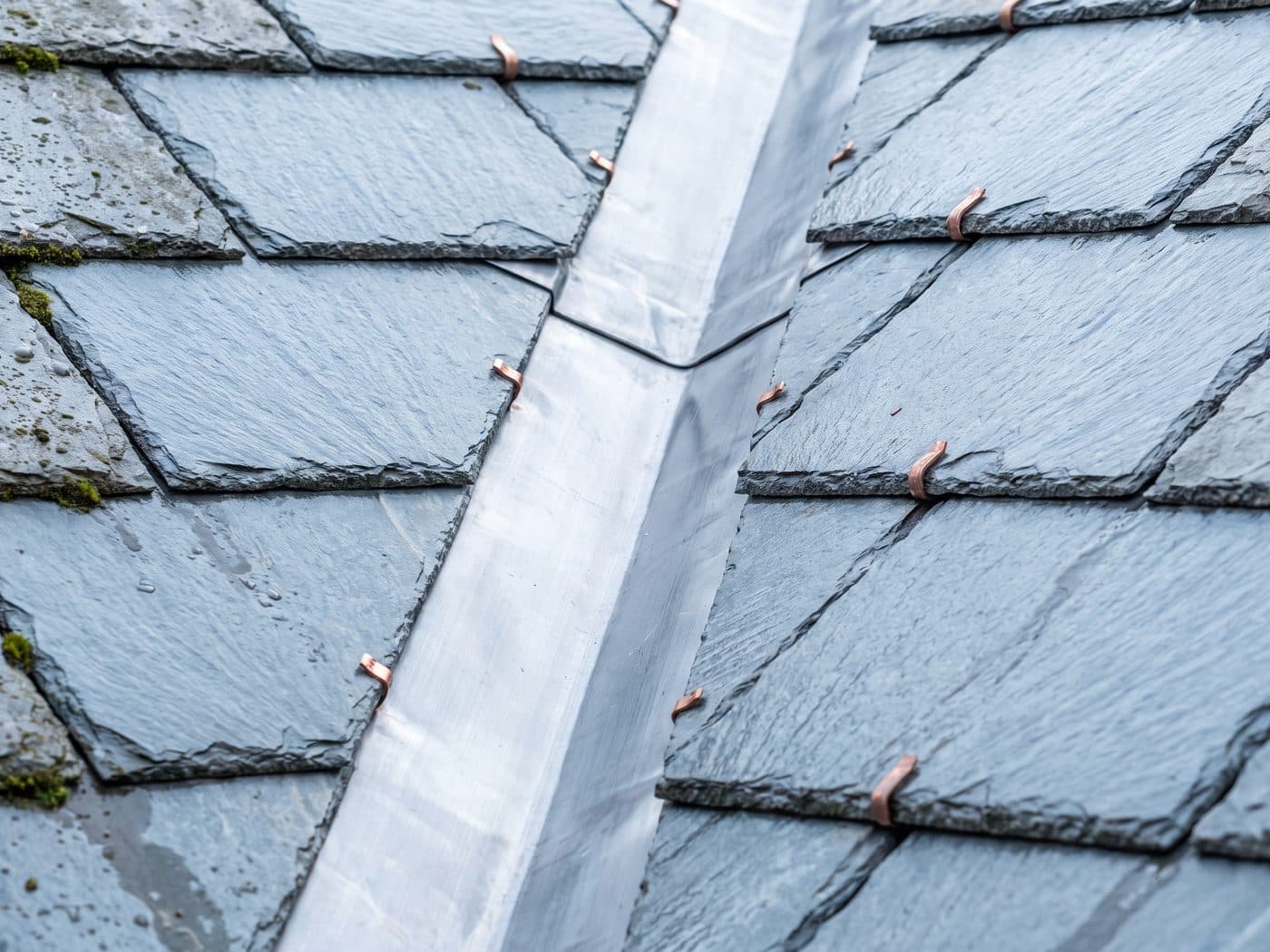 A newly formed lead valley running between two slate roof slopes